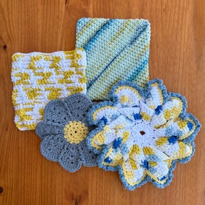 May include: Four crocheted dishcloths in a variety of patterns and colors. The dishcloths are in shades of blue, yellow, and white. The dishcloths are made with a cotton yarn.