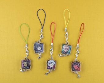 May include: Six colourful phone charms featuring different cartoon characters. Each charm is attached to a silver chain and a colourful string.