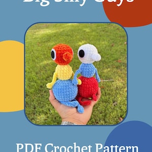Puede incluir: Dos pequeños juguetes de peluche hechos a mano con ganchillo, con cabezas, cuerpos y extremidades redondeadas. Uno tiene cabeza naranja, torso amarillo y base azul. El otro tiene cabeza blanca, torso azul y base roja. Texto Big Silly Guys PDF Crochet Pattern.