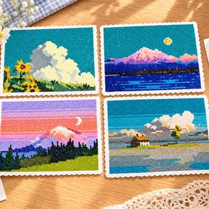 Könnte beinhalten: Vier rechteckige Karten mit gewelltem Rand zeigen Pixel-Art-Landschaften. Eine zeigt Sonnenblumen und Wolken, eine andere einen Berg bei Nacht, eine dritte einen Sonnenuntergang über einem Wald und die vierte ein Haus am See. Ein Etikett trägt die Aufschrift "Please wait the time" und "No one but you".