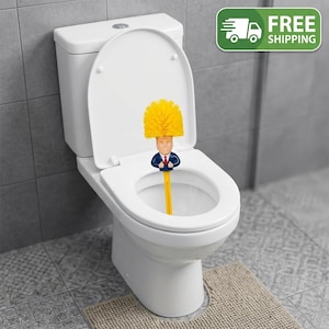 May include: A toilet brush featuring a yellow bristle head styled like hair atop a figure wearing a blue suit and red tie. The handle is yellow and the brush is positioned inside a white toilet bowl with the lid and seat in an upright position.