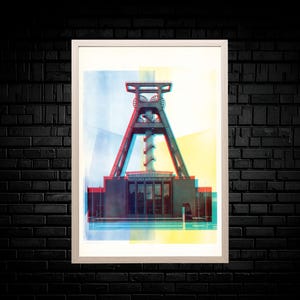 Könnte beinhalten: Ein gerahmter Kunstdruck mit einer stilisierten, mehrschichtigen Grafik des Deutschen Bergbau-Museums. Das Bild verwendet rote, blaue und gelbe Farbüberlagerungen, um einen 3D-Effekt auf dem industriellen Fördergerüst zu erzeugen.