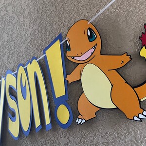 May include: A yellow and blue banner with the name "Jayson!" and a cartoon image of a brown and orange Pokemon character with a flame tail.