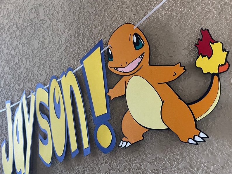 May include: A yellow and blue banner with the name "Jayson!" and a cartoon image of a brown and orange Pokemon character with a flame tail.