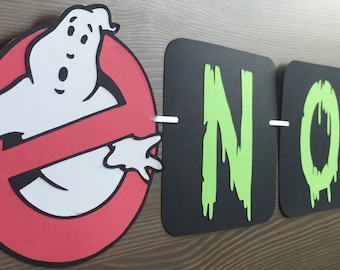 May include: A black and green banner with the name "NOAH" spelled out in dripping green letters. A red and white Ghostbusters logo with a white ghost is on the left side of the banner.