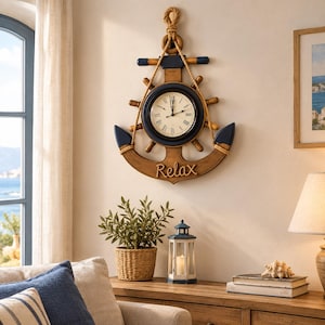 May include: A wall clock shaped like a ship anchor and steering wheel, featuring a cream-coloured face with black Roman numerals, dark blue accents, and a rope detail. The word Relax is written in script on the lower curve of the anchor frame.