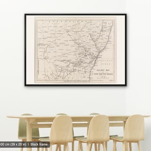 Könnte beinhalten: Eine gerahmte historische Eisenbahnkarte von New South Wales, Australien, mit detaillierten schwarzen Linien auf beigem Hintergrund. Die Karte enthält den Text RAILWAY MAP OF NEW SOUTH WALES und misst 100 mal 70 cm in einem schwarzen Rahmen.