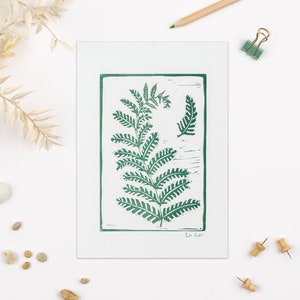 Fern lino print featuring a large and small fern side by side framed with a thin green line. Perfect for plant or nature lovers. Hand printed in Bristol
