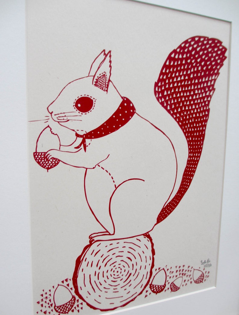 Puede incluir: Dibujo de l&iacute;nea roja de una ardilla con una bandana roja y sosteniendo una bellota. La ardilla est&aacute; sentada en un toc&oacute;n de &aacute;rbol con un patr&oacute;n de espiral rojo. Hay varias bellotas esparcidas alrededor del toc&oacute;n.