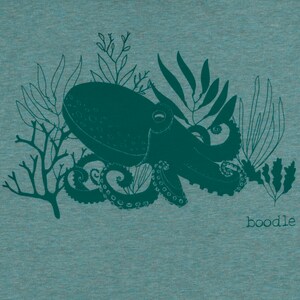 May include: A teal blue octopus with tentacles and seaweed design on a teal blue heather t-shirt. The text "boodle" is printed on the bottom right corner of the shirt.
