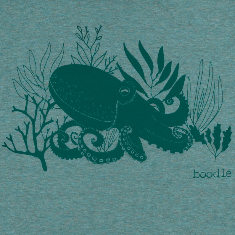 May include: A teal blue octopus with tentacles and seaweed design on a teal blue heather t-shirt. The text "boodle" is printed on the bottom right corner of the shirt.
