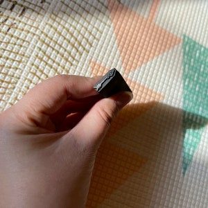 May include: A black metal stamp with a design of an arrow pointing to the right.