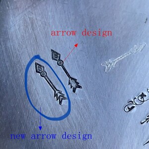 May include: Close-up of a metal surface with two arrow designs. The arrow on the left is labelled "new arrow design" and the arrow on the right is labelled "arrow design".