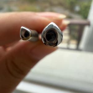 以下が含まれることがあります： 水滴型の銀色の金属製の物体2つのクローズアップ。物体は光沢のある反射面を持っています。左側の物体は丸みを帯びた端を持ち、右側の物体はより幅広く、より開いた端を持っています。