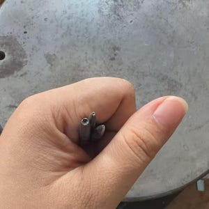 Pode incluir: Três pequenas ferramentas metálicas pontiagudas com pontas cónicas mantidas juntas. Cada ferramenta apresenta um acabamento liso cinzento-escuro e um corpo cilíndrico cónico, concebido para trabalhos de precisão ou marcação.