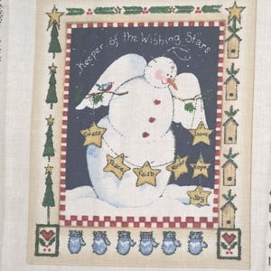 May include: A fabric wall hanging featuring a snowman with white wings against a dark blue background. The text reads Keeper of the Wishing Stars. The snowman holds a string of yellow stars labeled Grace, Peace, Faith, Honor, Love, Hope, and Joy. The border includes green trees, birdhouses, and blue mittens.