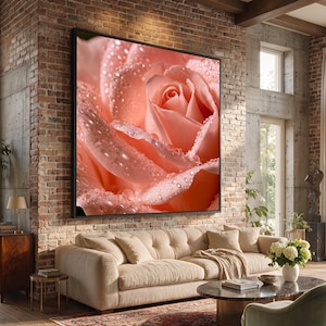 Peut inclure: Une grande œuvre d'art murale rectangulaire représentant un gros plan d'une rose couleur pêche douce avec des gouttelettes d'eau visibles sur ses pétales. L'œuvre est encadrée en noir et fixée sur un mur en briques apparentes au-dessus d'un canapé beige.
