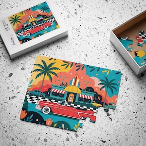 May include: A jigsaw puzzle featuring a colorful illustration of a red vintage convertible car parked in front of a retro diner with palm trees, a checkered floor pattern, and a bright sky. The puzzle is shown partially assembled with its box.