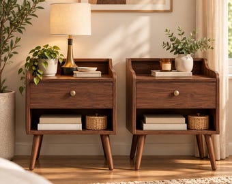 May include: Two matching dark wood nightstands with a single drawer featuring a small round brass knob. Each nightstand has an open storage shelf below the drawer, supported by four tapered legs. The surface holds a lamp and decor.