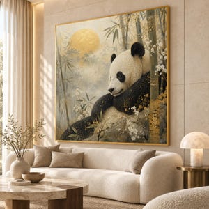 Op de afbeelding: Een vierkant wandkunstwerk met een panda die rust tussen bamboestengels en witte bloesems. De achtergrond bevat een groot, gestructureerd gouden cirkelvormig element dat op een zon lijkt, tegen een zacht, gedempt landschap.