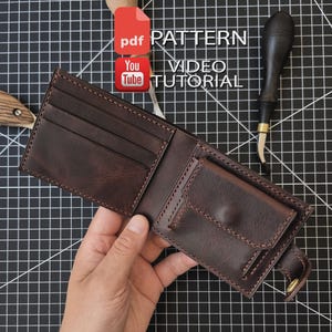 Könnte beinhalten: Ein dunkelbraunes Leder-Bifold-Portemonnaie mit mehreren Kartenfächern und einem Münzfach mit Druckknopfverschluss. Das Portemonnaie wird mit den Texten PDF PATTERN und VIDEO TUTORIAL angezeigt, was auf eine digitale Anleitung hinweist.
