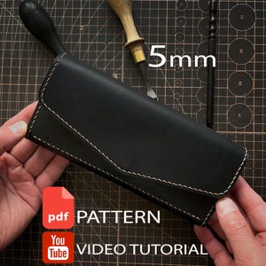 May include: A black leather wallet with a flap closure and light-colored stitching. The wallet is displayed with a wooden-handled tool and a black stylus. Text on the image reads 5mm, PDF PATTERN, and YouTube VIDEO TUTORIAL.