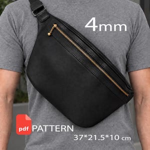 Può includere: Una borsa a tracolla nera con cerniera dorata e un tirazip sferico dorato. La borsa presenta un'etichetta PDF PATTERN, dimensioni di 37 per 21,5 per 10 cm e una specifica di spessore di 4 mm stampata sull'immagine.