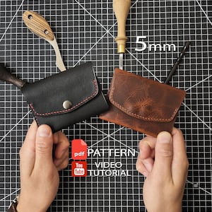 Könnte beinhalten: Zwei Kartenetuis aus Leder, eines in Schwarz mit roten Nähten und eines in Braun, werden zusammen mit Lederwerkzeugen wie einer Ahle mit Holzgriff und einem Messer gezeigt. Der Text 5mm, pdf PATTERN und YouTube VIDEO TUTORIAL ist sichtbar.
