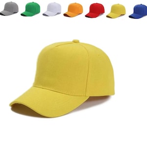 May include: A bright yellow baseball cap with a structured five-panel crown, a curved brim, and a solid fabric construction. The top row of the image displays a variety of baseball caps in grey, green, white, orange, red, yellow, and blue.