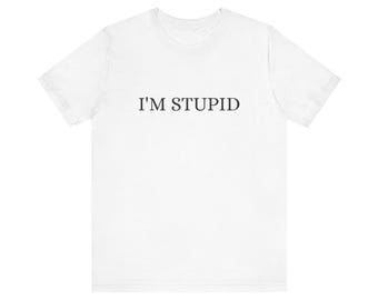 May include: A white short-sleeved t-shirt featuring the text I'M STUPID printed in a simple black serif font across the center of the chest. The garment has a crew neckline and a standard fit, presented against a plain, neutral background.
