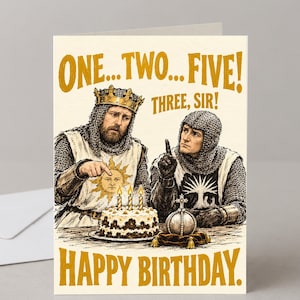 May include: A greetings card featuring an illustration of two medieval figures in chainmail and tunics. One points at a birthday cake with three lit candles, while the other holds up one finger. Text reads: ONE...TWO...FIVE! THREE, SIR! HAPPY BIRTHDAY.