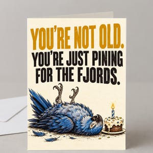 May include: A greeting card with a cream background featuring a blue parrot lying on its back with its feet in the air. Next to the bird is a small chocolate cake with a single lit candle. The text reads: YOU'RE NOT OLD. YOU'RE JUST PINING FOR THE FJORDS.