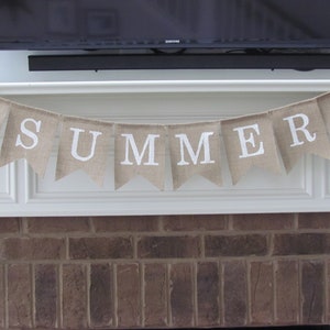 May include: A burlap banner with the word "SUMMER" in white letters and watermelon illustrations on each end.