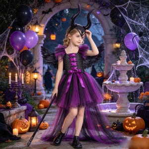 May include: A child wearing a black and purple high-low dress with a corset-style bodice, ruffled shoulders, and black feathered wings. The outfit includes a black headpiece with two curved horns and a black staff with a pointed top.