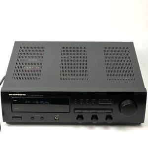 May include: A black Marantz SR-66 hi-fi stereo receiver featuring a digital display showing FM 106.10, a large volume knob on the right, multiple control buttons, and a headphone jack. The top panel has three rectangular ventilation grilles.