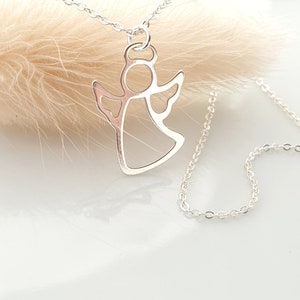 May include: A silver chain necklace with a delicate angel pendant. The angel is cut out in a simple, elegant design.
