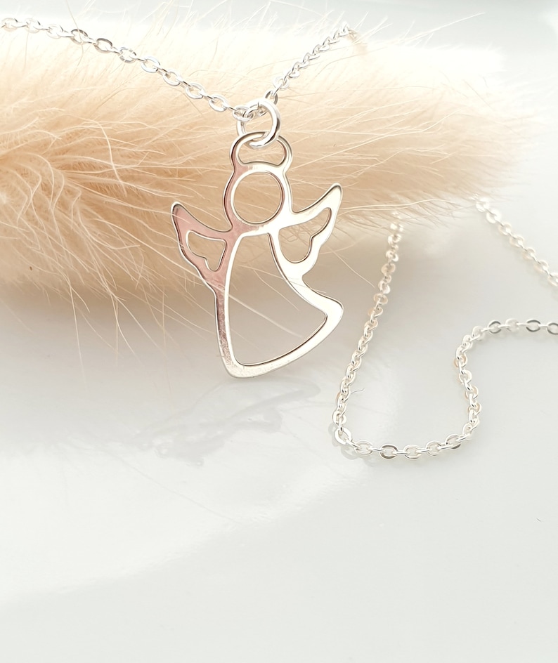 May include: A silver chain necklace with a delicate angel pendant. The angel is cut out in a simple, elegant design.