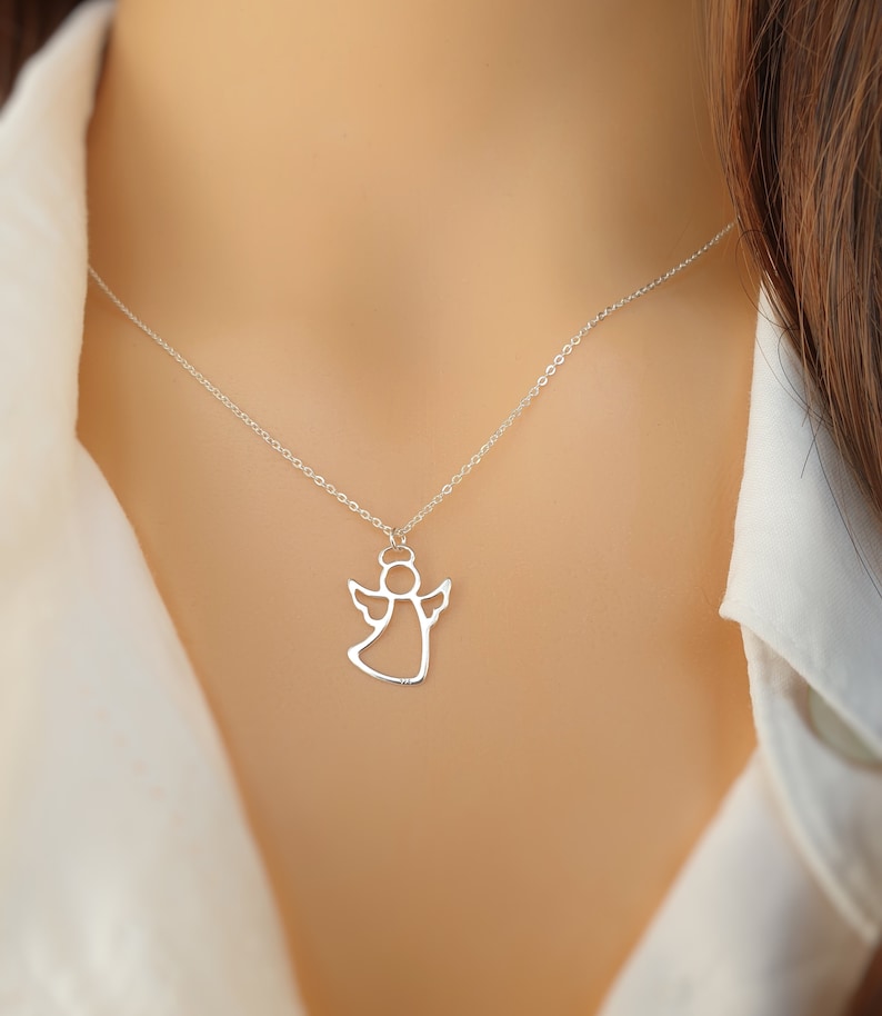 May include: A silver chain necklace with a delicate angel pendant. The angel is outlined in silver and has a halo.