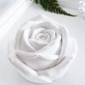 Puede incluir: Una rosa de cerámica blanca con un diseño detallado y realista. La rosa es un objeto decorativo y es perfecta para añadir un toque de elegancia a cualquier hogar.