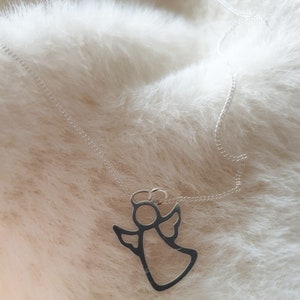 May include: A silver chain necklace with a delicate angel pendant. The angel is outlined in silver and has a halo.