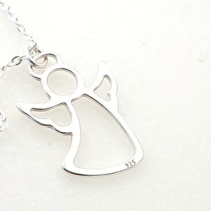 May include: Silver angel pendant necklace with a delicate outline design. The pendant has a 925 stamp on the back.