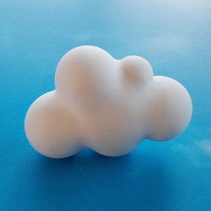 Könnte beinhalten: Eine weiße Keramik-Wolken-Skulptur mit einer abgerundeten, organischen Form. Die Wolke besteht aus mehreren verbundenen Kugeln, die ein skurriles und abstraktes Design erzeugen.