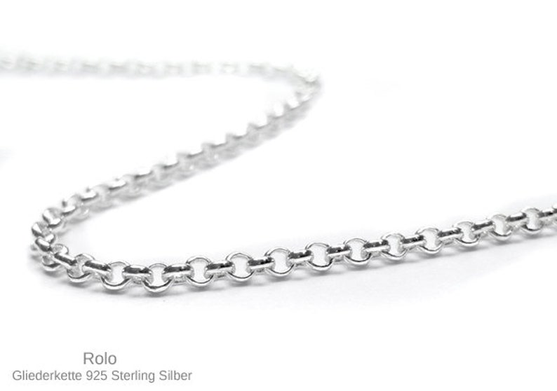 May include: A close-up of a silver Rolo chain necklace. The chain is made of small, round links and is displayed against a white background. The text "Rolo Gliederkette 925 Sterling Silber" is at the bottom.
