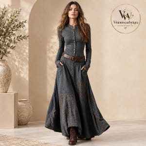 Könnte beinhalten: Ein anthrazitfarbenes, langärmeliges Maxikleid mit durchgehender Knopfleiste, Stehkragen und Seitentaschen. Der Rock ist mit dunklen Karomustern im Patchwork-Stil versehen. Ein brauner Ledergürtel mit runder Schnalle wird in der Taille getragen.