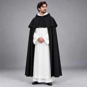 May include: A floor-length black hooded cape worn over a white long-sleeved robe. The cape features a structured hood and a wide shoulder mantle, while the white robe has long, loose sleeves and a straight, clean-cut hemline.