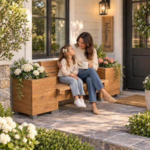 May include: A wooden bench with integrated side planters featuring horizontal slats and a natural finish. The bench is positioned on a stone patio and is adorned with white hydrangea flowers in the planters. A vertical wooden sign reads Welcome.