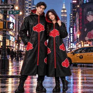 May include: Two long black hooded coats featuring a bright red zipper down the front and a red cloud pattern printed across the fabric. The coats have long sleeves and reach below the knees, worn with black boots in a city street setting.