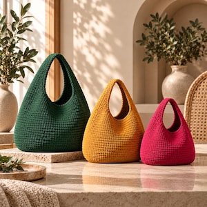 May include: Three hobo-style bags crafted from a dense, textured knit fabric. The bags are arranged in a row by size, featuring a large dark green bag, a medium mustard yellow bag, and a small magenta pink bag, each with a single integrated handle.