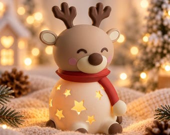 May include: A beige reindeer figurine with brown antlers, a dark brown nose, and pink cheeks, wearing a red scarf. The lower body is a rounded, cream-colored base featuring star-shaped cutouts that emit a warm, glowing light from within.
