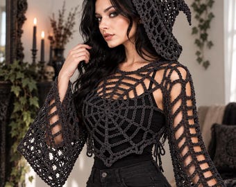 May include: A dark gray crochet hooded top featuring an open-knit spiderweb pattern across the chest and long, flared sleeves. The garment is worn over a black tank top and paired with black jeans, creating a layered look with a pointed hood.